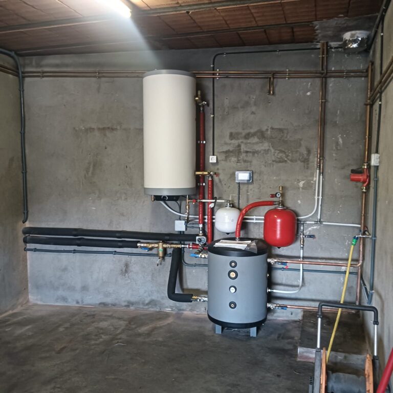 Instal·lació interior d’aerotèrmia amb acumulador i connexió a radiadors en un habitatge de Puig-reig